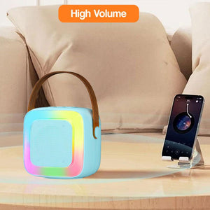 Family Fun Karaoke Machine portable Bluetooth speaker with colorful lights on table beside smartphone