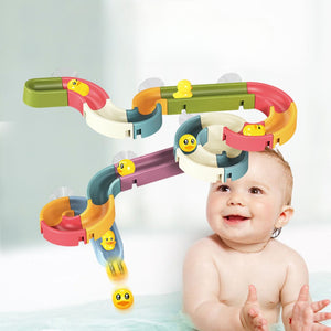 Baby playing with colorful DIY water play track bath toy set with floating ducks