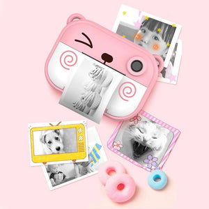 Pink kids instant print camera printing black and white photos with decorative frames on pink background