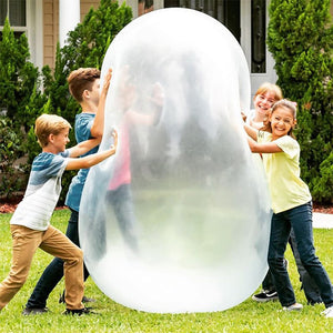 Kids playing outdoors with giant jelly balloon ball on grass for active fun
