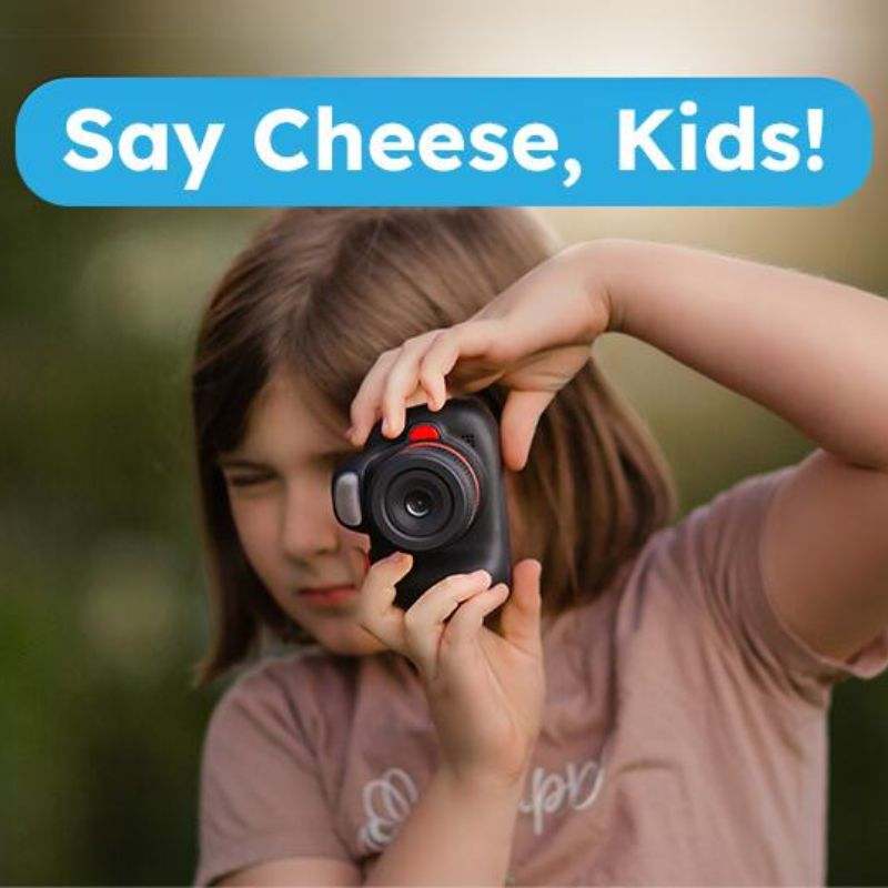 Child using Mini Photographer Digital Camera to take a photo with "Say Cheese, Kids!" text above