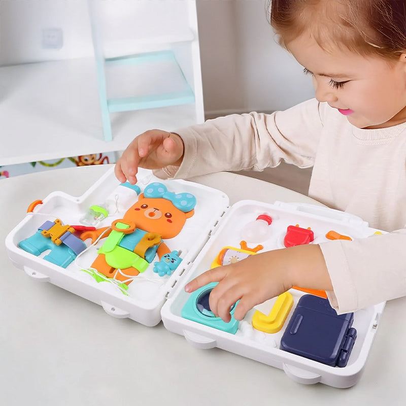 Toddler playing with white Busy Board Montessori educational toy with interactive elements on a table